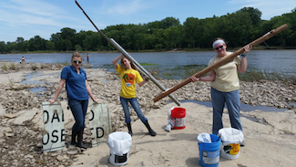 Volunteers working to collect litter along the Maumee River