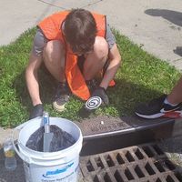 A Navarre elementary Student prepares a storm drain medallion to be placed on a catch basin.